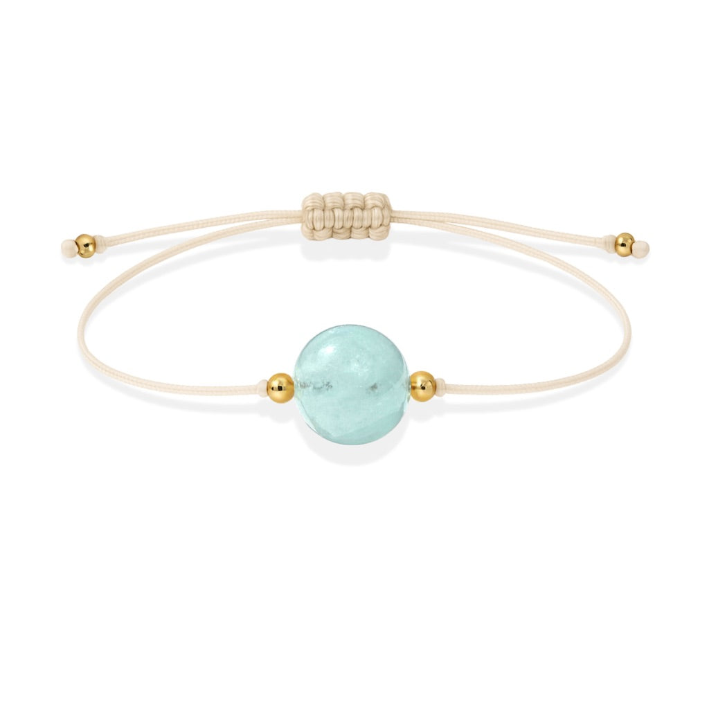 Pulsera de aguamarina natural con hilo color hueso y balines en oro de 18 quilates.