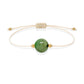 Pulsera de esmeralda natural con hilo color hueso y balines en oro de 18 quilates.