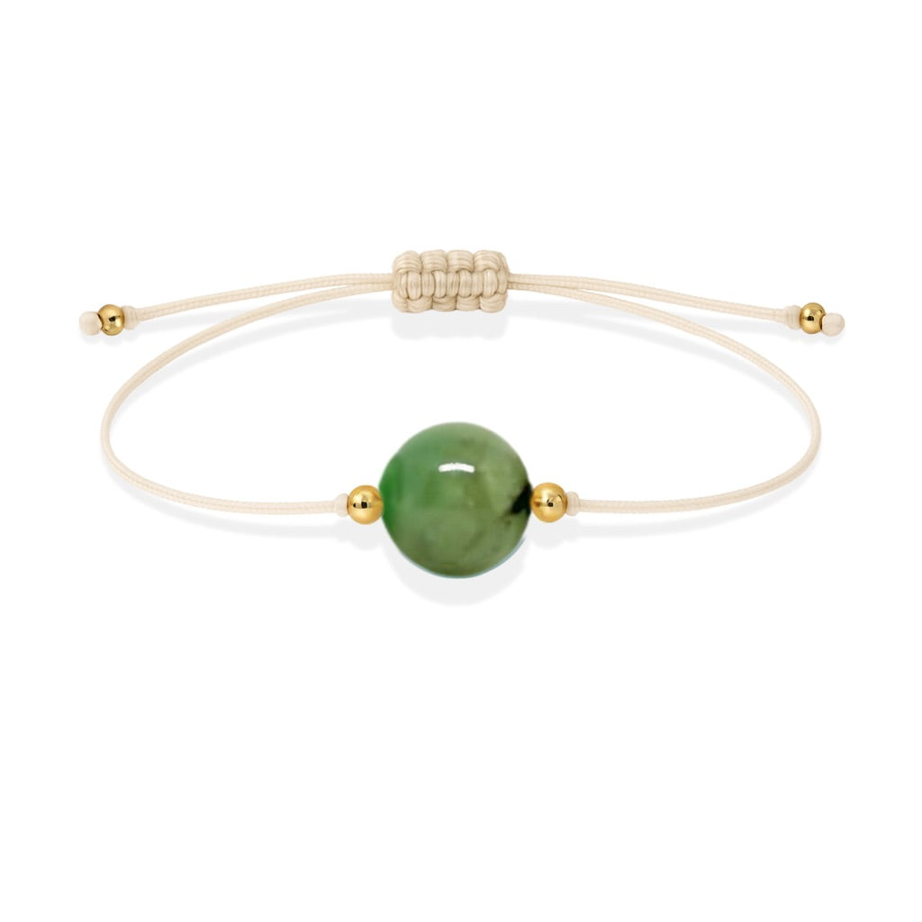 Pulsera de esmeralda natural con hilo color hueso y balines en oro de 18 quilates.