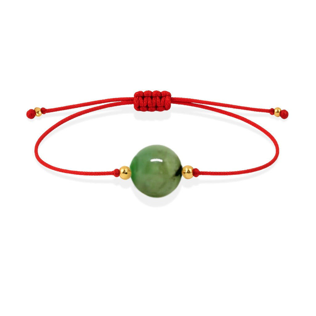 Pulsera de esmeralda natural con hilo rojo y balines en oro de 18 quilates.