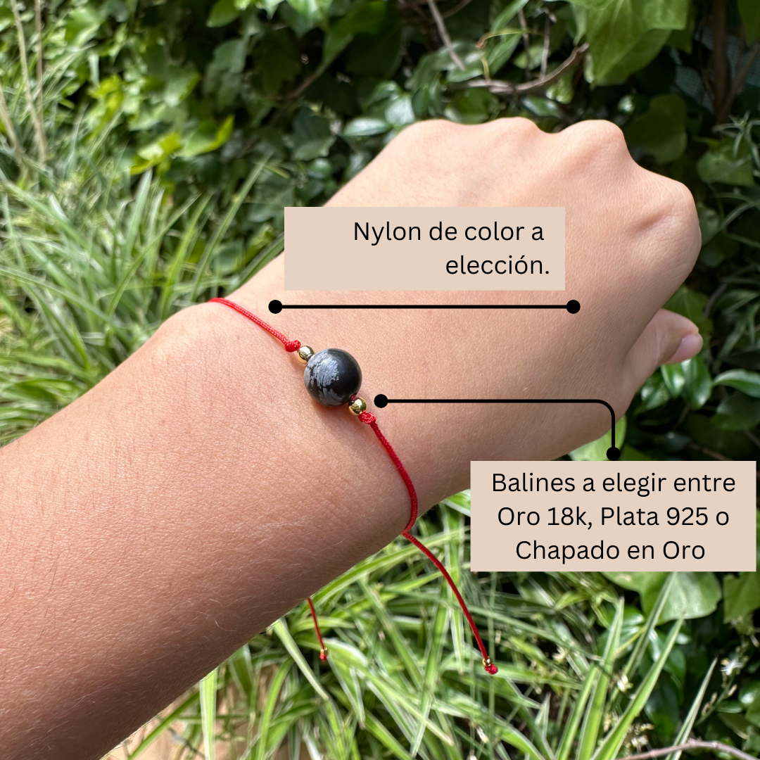 Pulsera de obsidiana nevada en la muñeca – ideal para claridad mental y protección